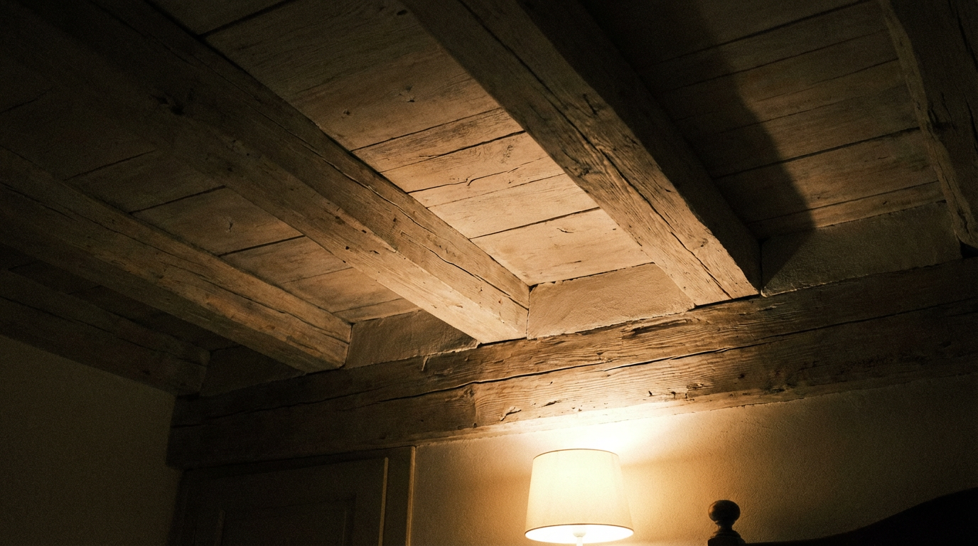 Techo de dormitorio con vigas de madera durante la noche mostrando detalles estructurales